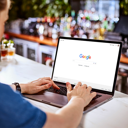 Um membro da equipe da DBA trabalhando em um notebook mostrando a página principal do Google.