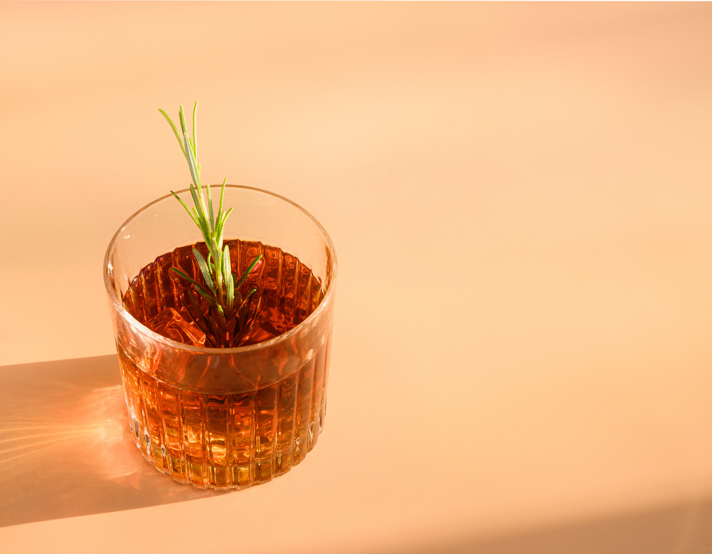 Copo de Whisky com gelo e guarnição de alecrim