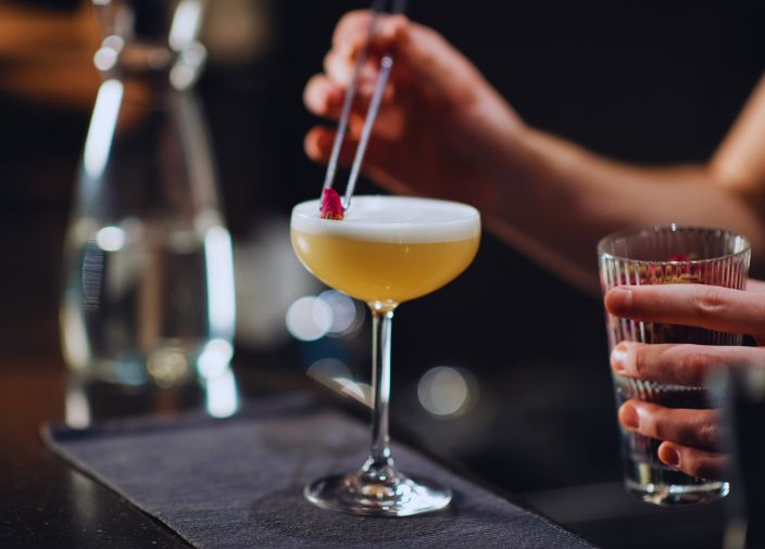 Bartender colocando el garnish en un cóctel premium 