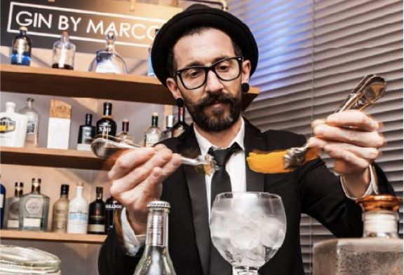 Bartender adornando un cóctel con una piel de naranja