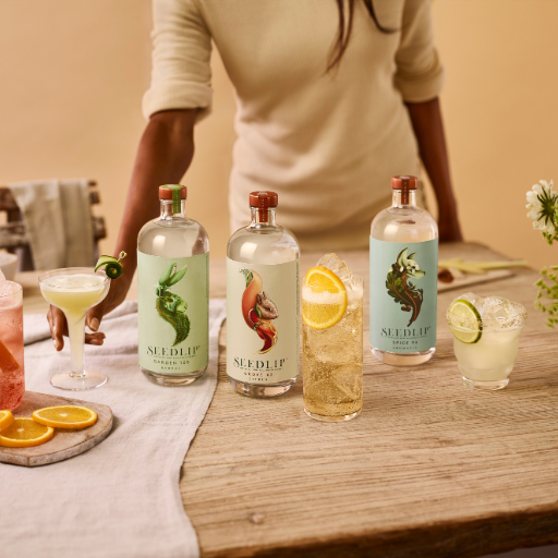 Selección de botellas de Seedlip sobre la mesa rodeadas de cócteles variados. 