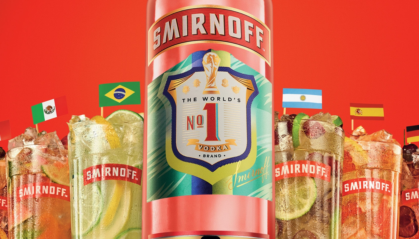Garrafa vermelha de Smirnoff com rótulo comemorativo de troféu ao centro. Ao redor, cinco copos altos da marca contêm diferentes coquetéis refrescantes com frutas e gelo, cada um decorado com a bandeira de um país. Fundo vermelho vibrante.