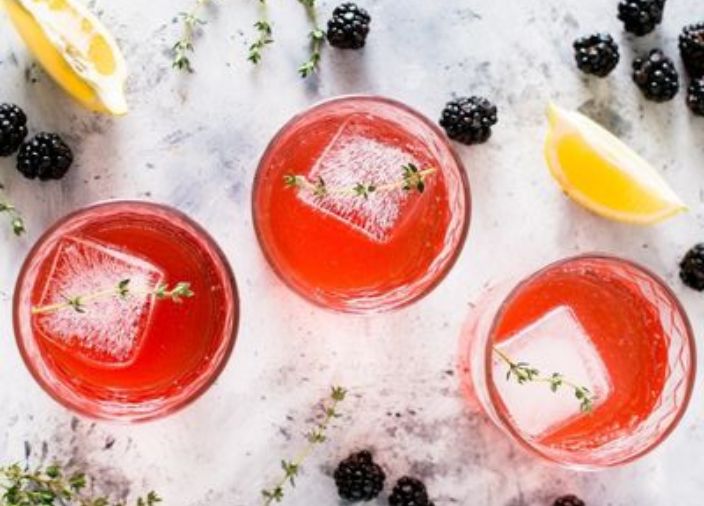 Tres cócteles de naranja con limones y frutas mixtas.