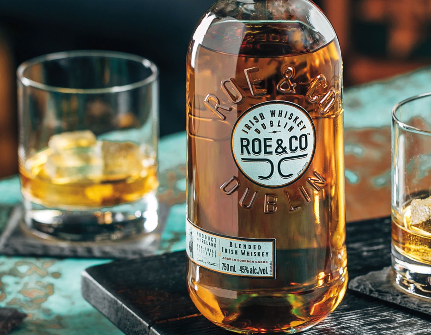 Two glasses of whiskey with ice. Pouring of whiskey in the second glass