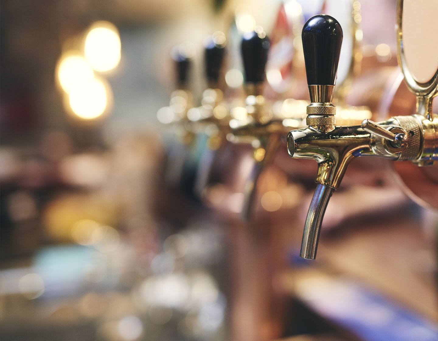 Reihe von Bierzapfhähnen in einer Bar.
