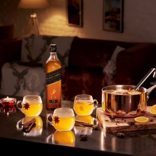 Ein Topf Hot Toddy, eine Flasche Johnnie Walker und drei Hot Toddies.