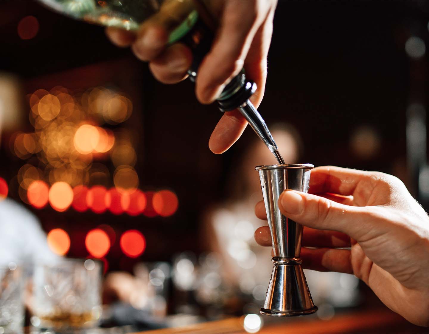 Close up shot of liquid being poured into a jigger