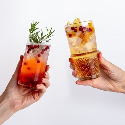   Two highball cocktails being clinked together to cheers 