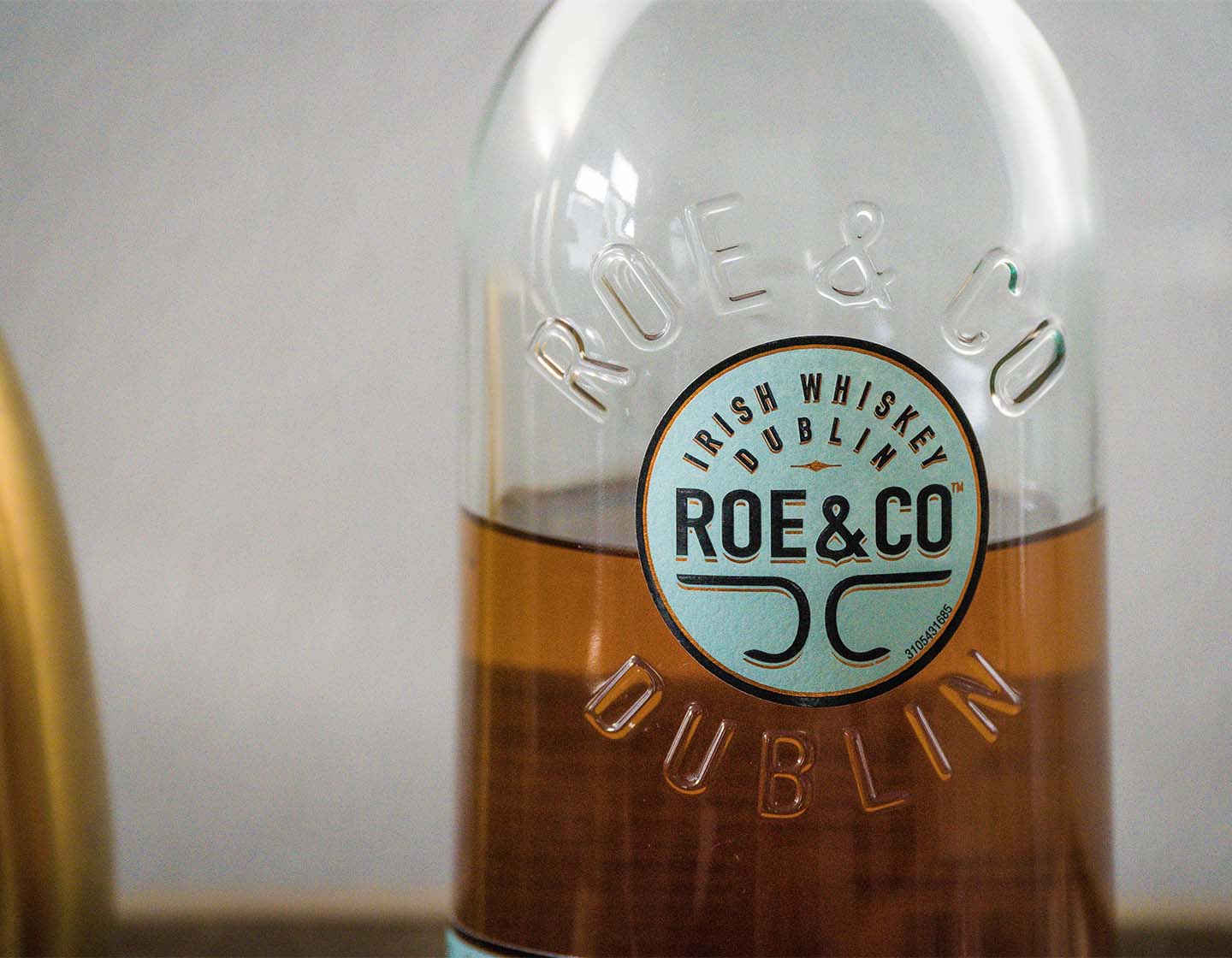 Uma foto de perto de uma garrafa de Whiskey irlandês da Roe & Co