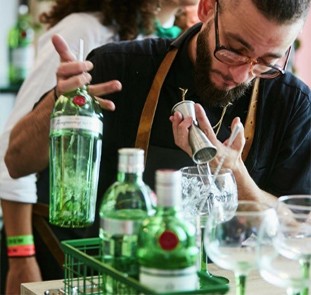 Imagem de um bartender despejando gin com um dosador