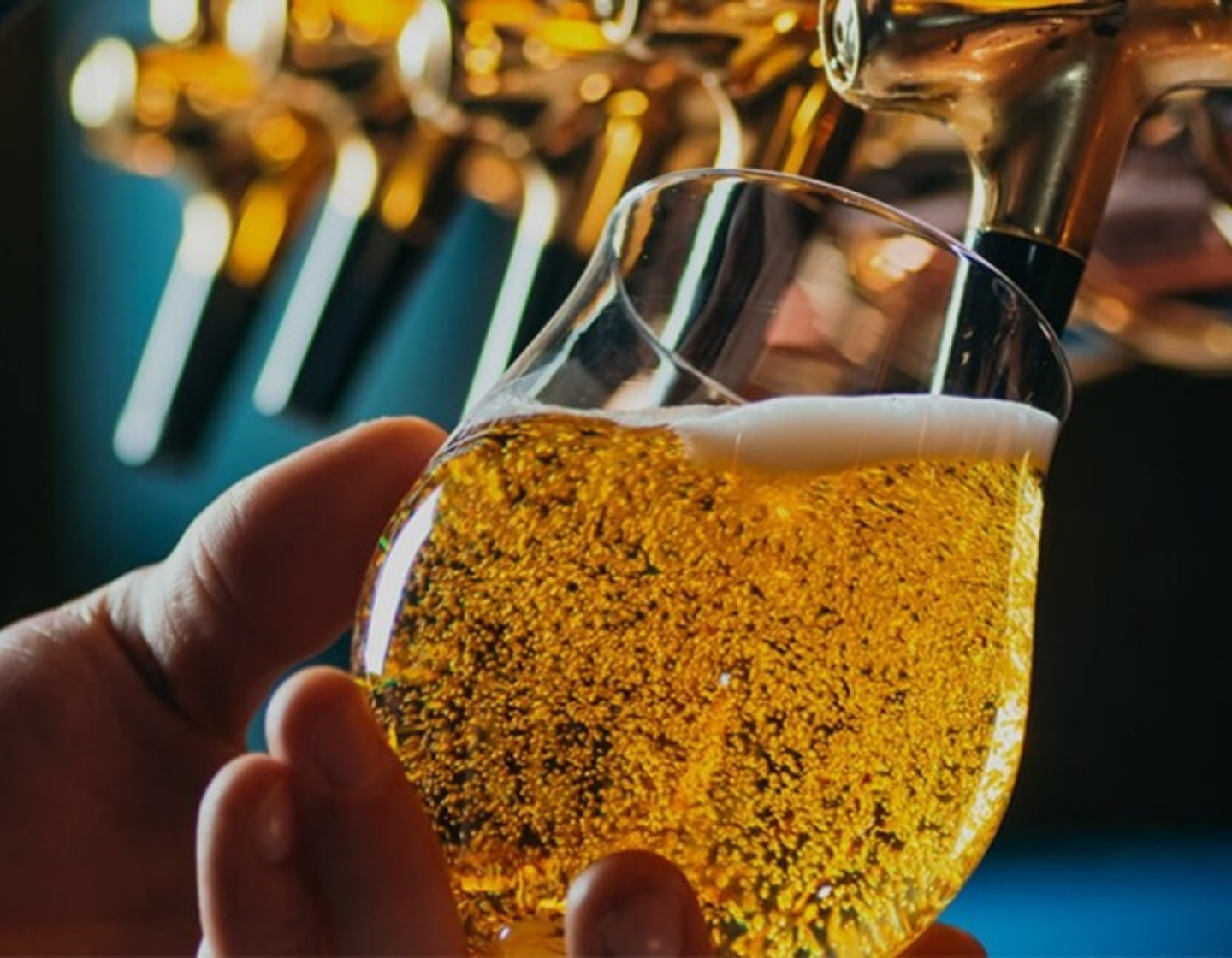 Cold glass of beer being poured in a bar