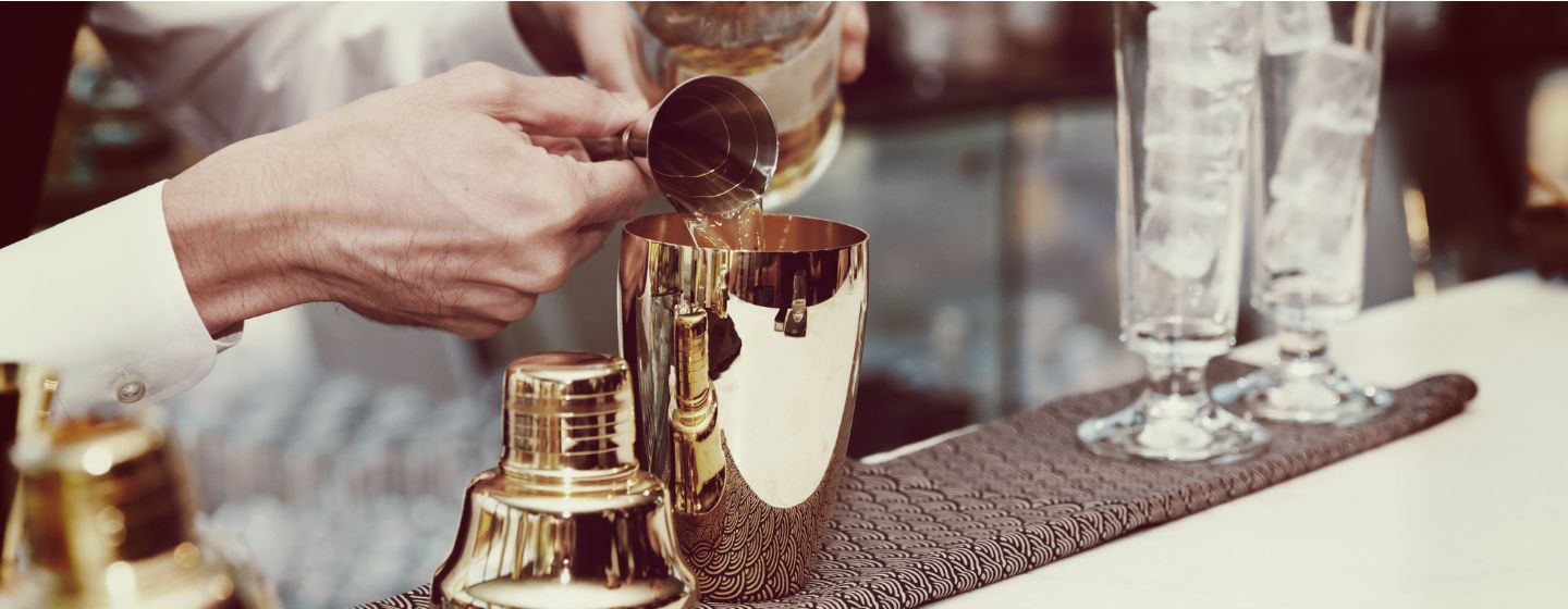  Imagem de um bartender colocando a bebida na coqueteleira 