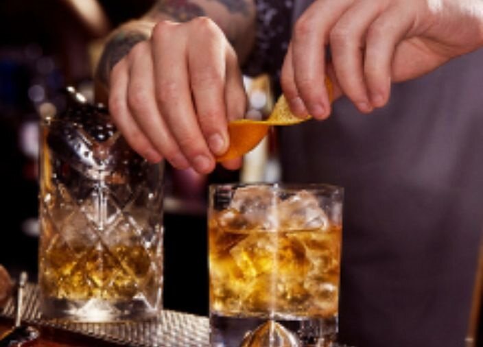 Bartender adornando whisky escocés con un toque cítrico