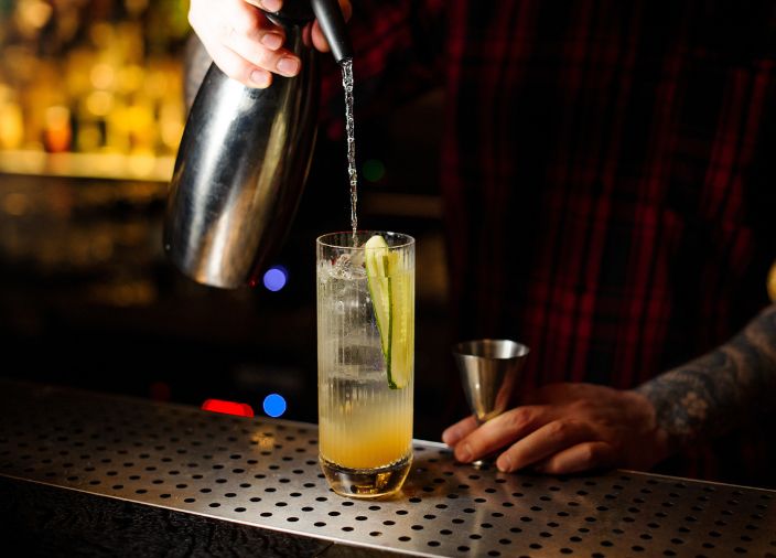 Bartender adding soda water to Cobble Hill cocktail