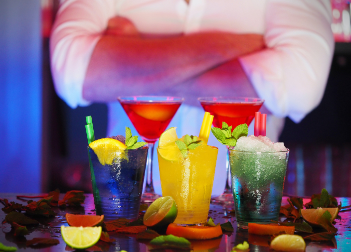  Bartender standing behind bar with drinks  