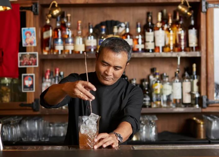 Yangdup Lama stirring cocktail on a bar
