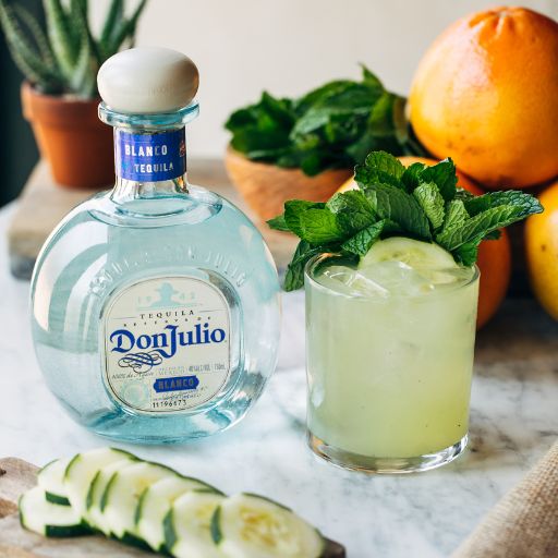  A bottle of Don Julio with a cocktail and limes 