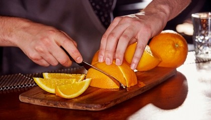Bartender cutting an orange