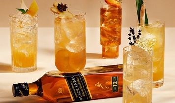 Johnnie Walker Flasche neben Highballs Drinks