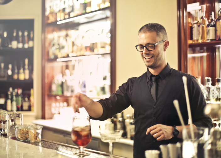 Bartender sonriente preparando una bebida