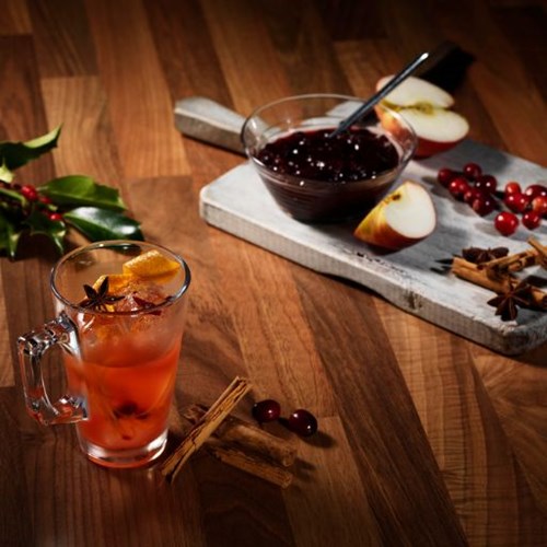   Christmas Cocktail surrounded by spices and fruit 