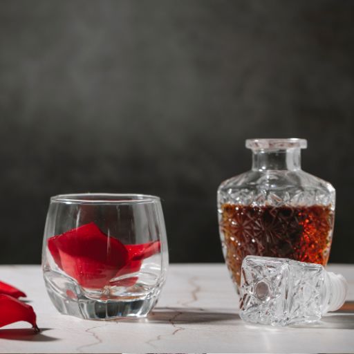 Un vaso y una jarra de brandy sobre una mesa