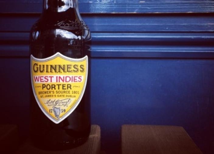 Bottle of Guinness West Indies Porter sat on a wooden table