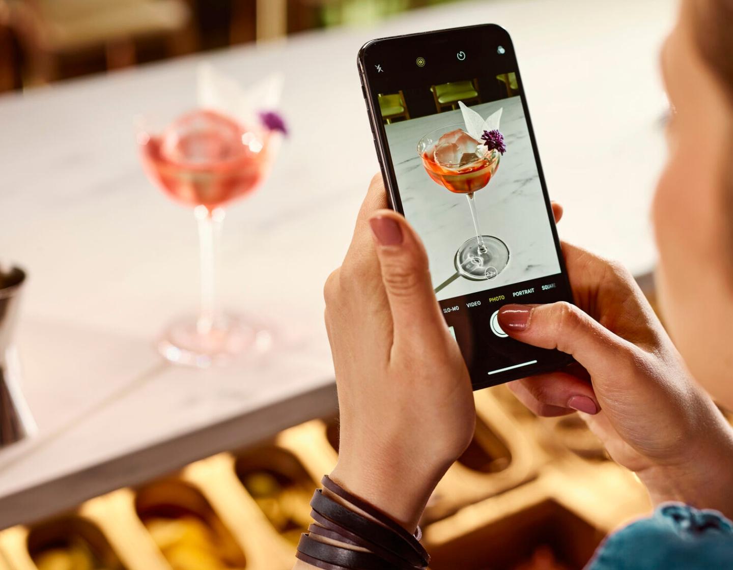 Customer taking photo of trendy cocktail 