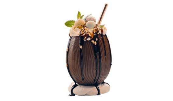 Drink festivo com baileys servido com um canudo e guarnições