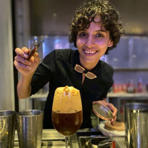 Ami Shroff mit einem dunklen Drink, dem Namaste Honey