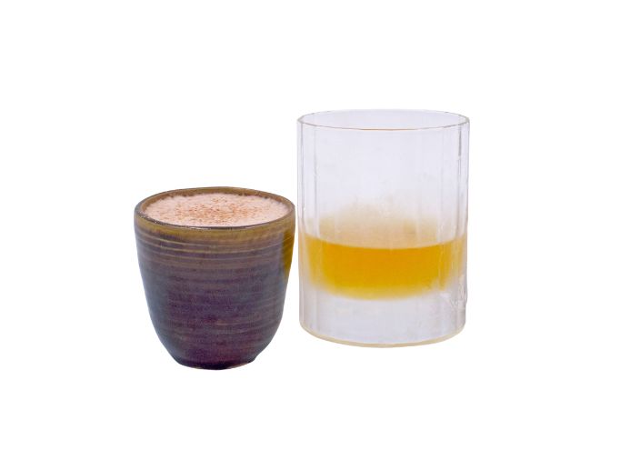 Un vaso de Dalwhinnie junto a una taza pequeña de Kings of Winter, una bebida de chocolate caliente con whisky Dalwhinnie.