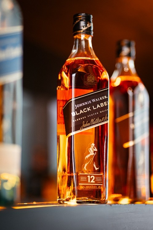 Botella de Johnnie Walker Black Label junto a un vaso de whisky