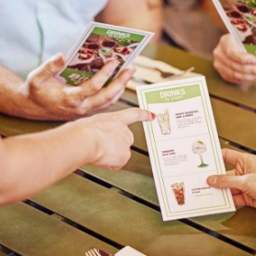 Menú de alimentos y bebidas en un bar con un cliente señalando un artículo