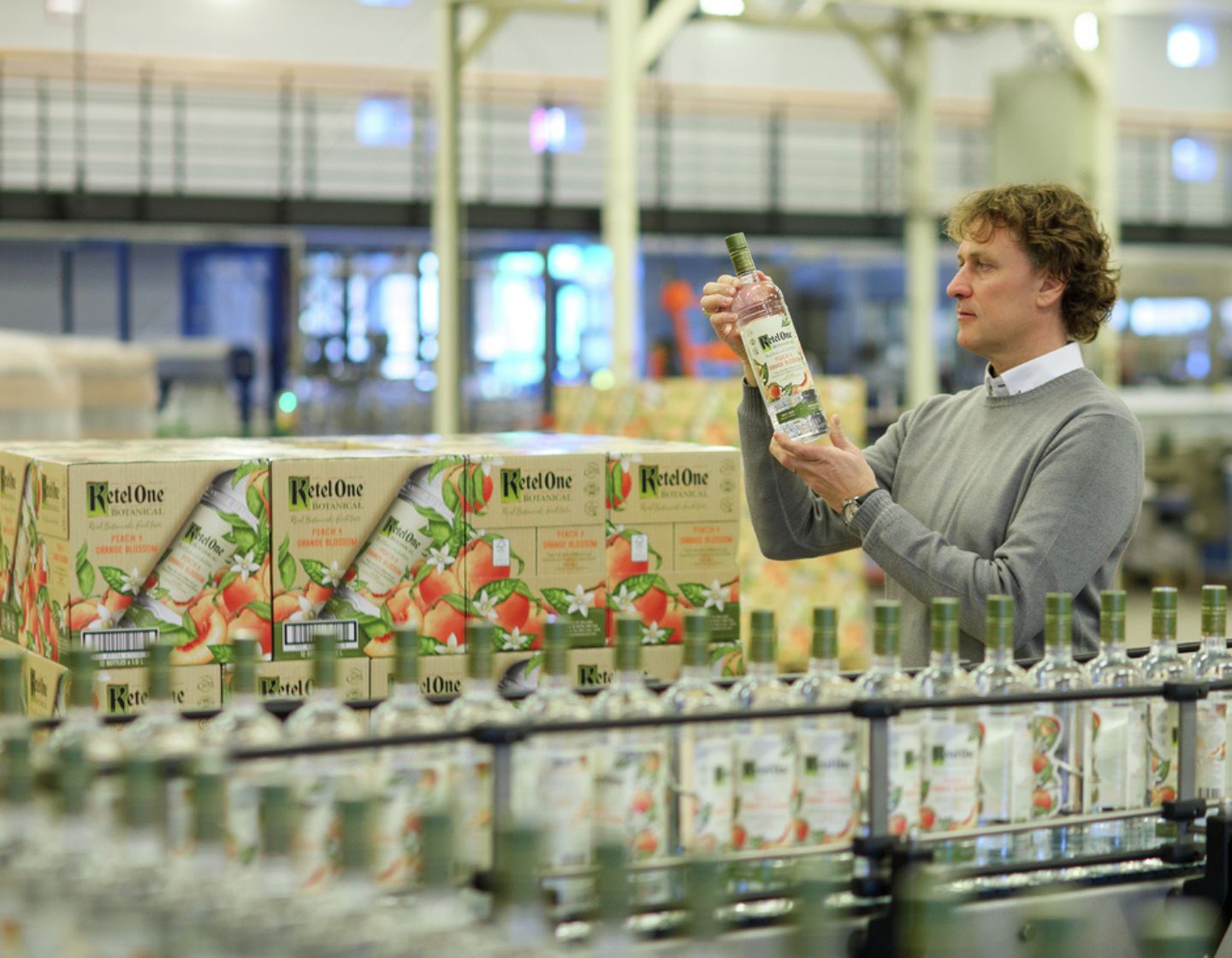 A man inspects a bottle of Ketel One before packaging