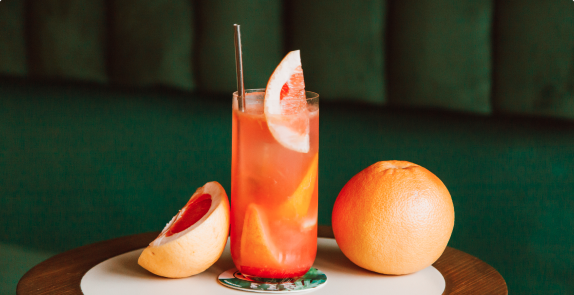 Grapefruit flavoured cocktail garnished with a wedge of gapefruit
