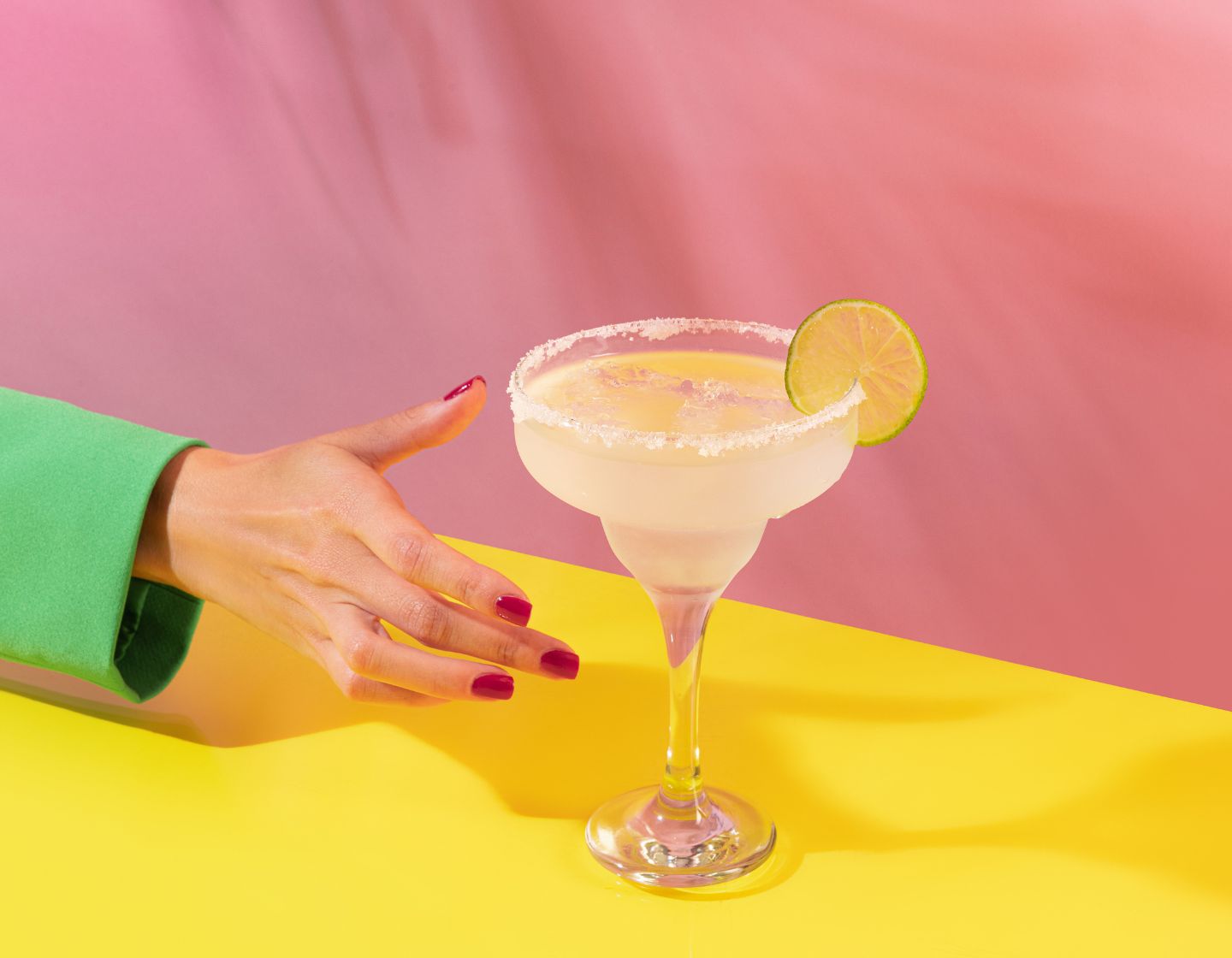 Uma mão feminina estendendo-a para servir uma margarita clássica