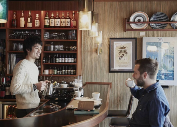 A customer enjoys a coffee and conversation with the barista at Fuglen, Tokyo 