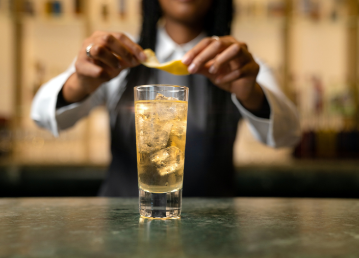 Bartender añadiendo especias a un cóctel 