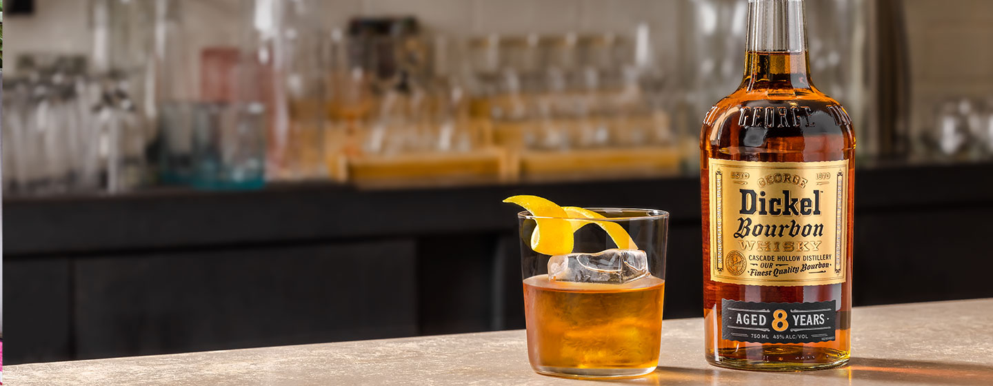 Bottle of Dickel on table with cocktail