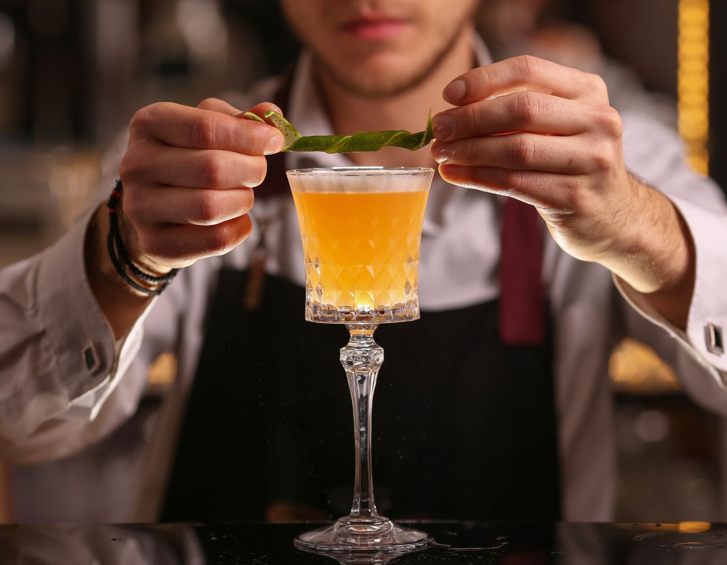 Bartender añadiendo un garnish de lima a un cóctel 