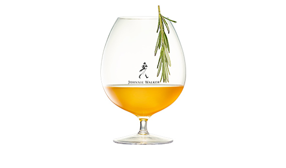 Hot Toddy in a short wine glass with pine leaf garnish