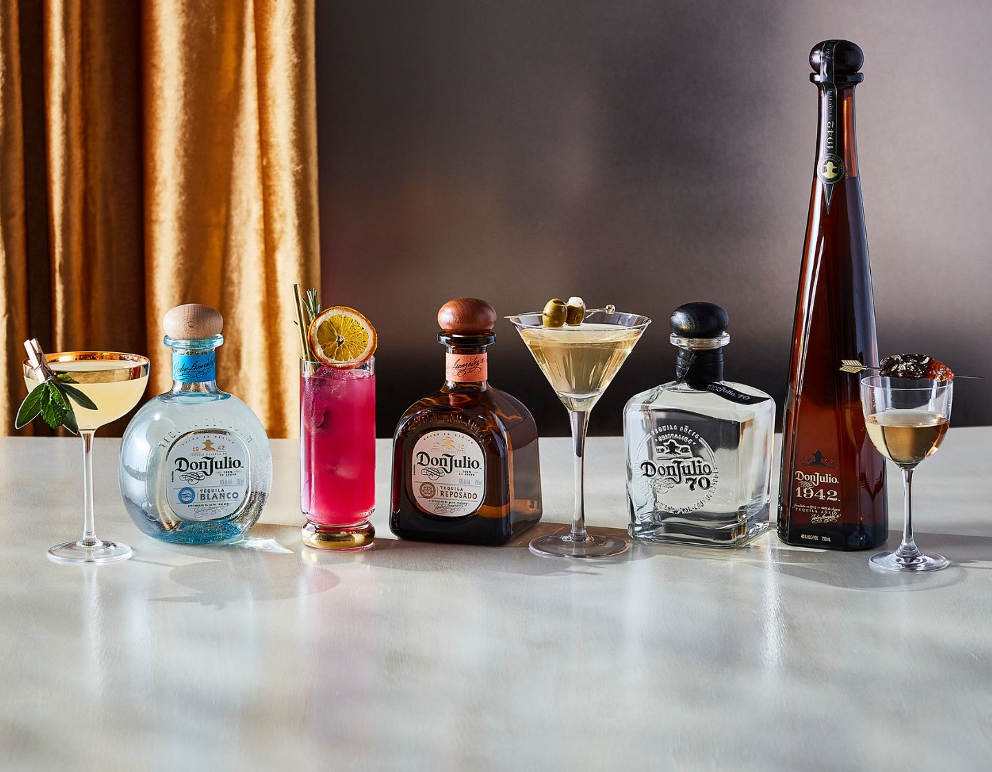 Selection of different bottles of Don Julio tequila positioned on wooden table