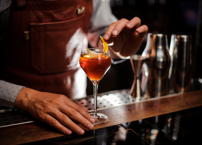 Imagem de um bartender decorando um coquetél