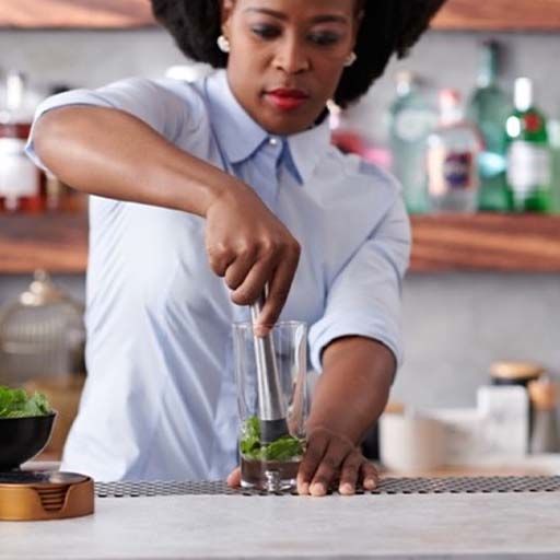 Una mujer usando un triturador en la cocina.