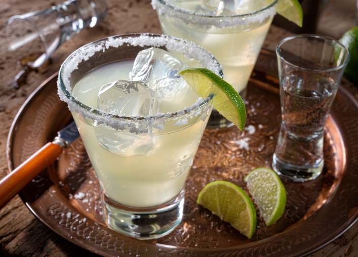Cóctel de tequila en un jigger amarillo y un adorno de limón