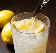 sirviendo un coctel en vaso con naranja