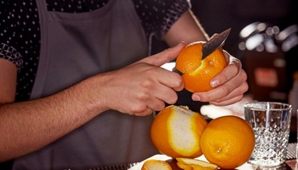 Bartender cutting an orange
