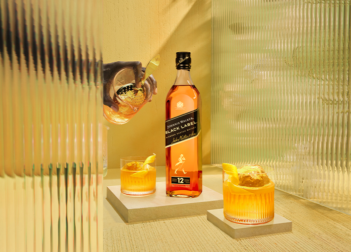 Una botella de Johnnie Walker Black label con dos copas de cóctel