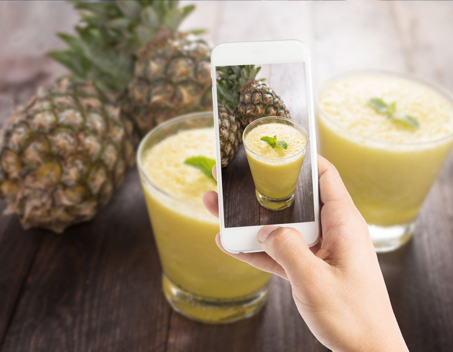Bartender using smartphone to capture photo of cocktail for social media
