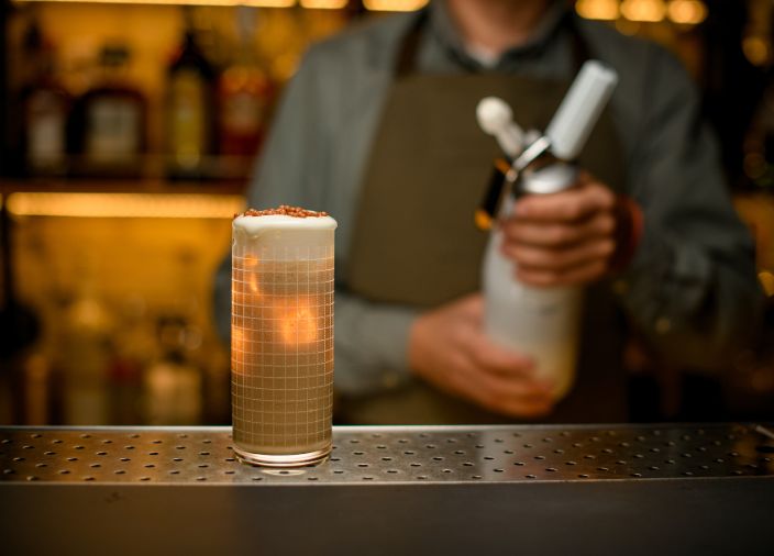Bartender con herramienta de espuma.